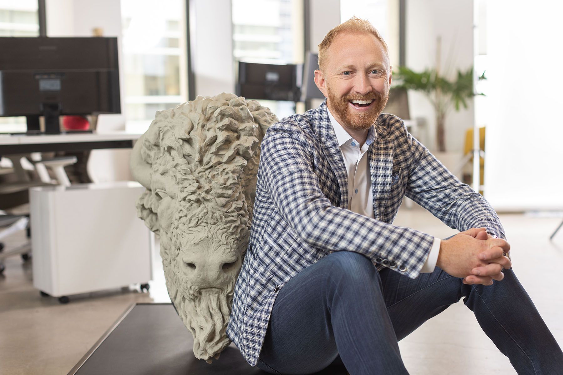 Darren Engels, Tailwind founder and CEO, sits in his office with his concrete Bison from the historical Centre Street Bridge in Calgary.